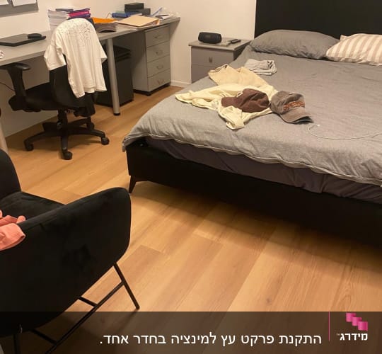 רצפת פרקט בחדר שינה עם מיטה ושולחן עבודה